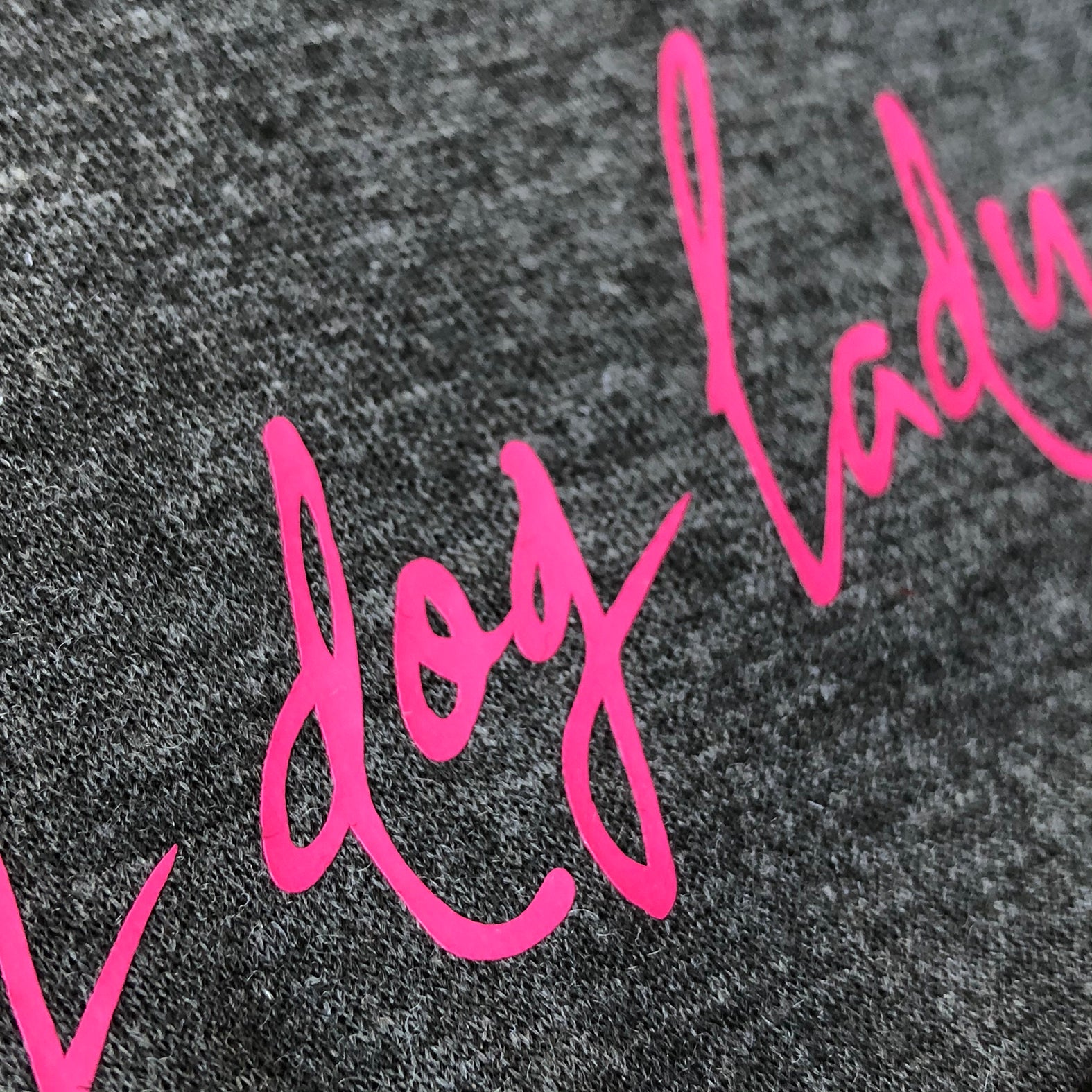 Dunkelgraue Beanie Mütze aus Jersey mit pinkfarbenem Aufdruck - Nahansicht der Schrift